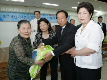 ▲ 해청기계 최상영(오른쪽 두 번째) 회장이 여성 자원봉사자들과 자매결연을 한 홀몸어르신에게 쌀을 전달하고 있다.