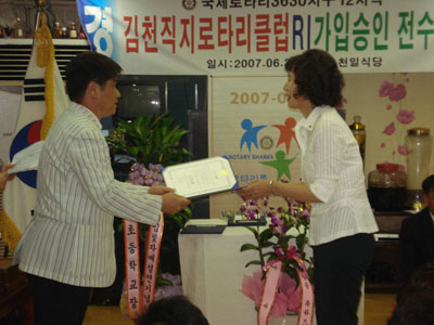 김천직지로타리클럽 박순희(오른쪽) 회장이 능치초교 어성철 교무주임과 자매결연 협약서를 체결하고 있다.