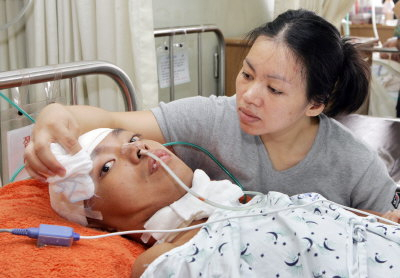 ▲ 교통사고로 전신이 마비된 채 7개월째 대구가톨릭병원에서 투병중인 필리핀인 왕사안 넬란띠(30) 씨를 부인 제니퍼 씨가 간호하고 있다. 김태형기자 thkim21@msnet.co.kr