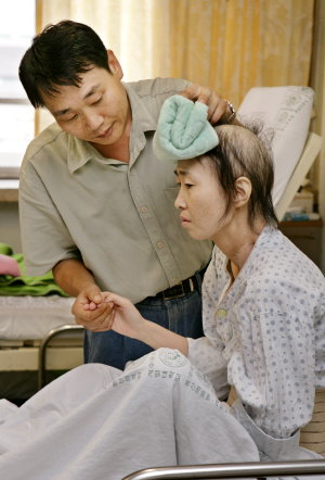 ▲ 김성민 씨가 27일 대구의 한 대학병원에서 암 투병 중인 아내 박명순 씨의 머리칼을 쓰다듬고 있다. 이채근기자 mincho@msnet.co.kr