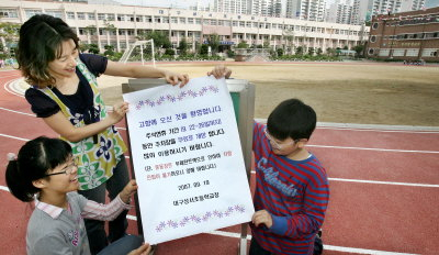 ▲ 19일 오후 대구 성서초등학교 학생과 교사가 운동장에서 추석 연휴기간 귀성객과 시민들의 주차 편의 제공을 위해 학교운동장을 무료 개방한다는 안내문을 붙이고 있다. 정운철기자 woon@msnet.co.kr