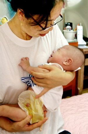 ▲ 조선족 엄마 이복이 씨가 항문이 없어 고통스러워하고 있는 생후 100일된 지윤이를 안고 달래고 있다. 이채근기자 mincho@msnet.co.kr
