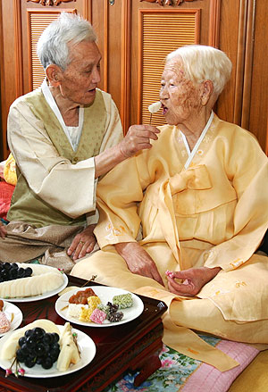 ▲ 내년 결혼 80주년을 맞는 성학환 옹이 부인 조성희 할머니에게 다과를 집어주고 있다.