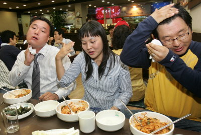 ▲ 매운 맛 마니아 노상기·방미명·윤정섭(왼쪽부터) 씨가 매운 낙지볶음을 먹으면서 즐거워하고 있다. 정운철기자 woon@msnet.co.kr