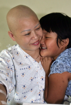 ▲ 유방암을 앓고 있는 안옥분(46) 씨가 늦둥이 딸 유림(9)이와 함께 병실에서 함박웃음을 짓고 있다. 보증금 500만 원에 월세 25만 원으로 작은 단칸방을 얻었지만 모녀는 병실에서 생활하고 있다. 