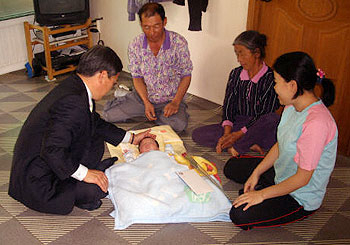 ▲ 거창군 고제면 이상준 면장이 23년 만에 태어난 영민이와 가족들을 격려하기 위해 삼포마을을 방문해 기쁨을 함께하고 있다.