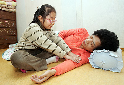 ▲ 이진숙 씨는 위암과 싸우며 단칸방에서 홀로 삼남매를 키우고 있다. 이 씨의 막내 보희가 엄마의 다리를 주물러 주고 있다. 정운철기자 woon@msnet.co.kr