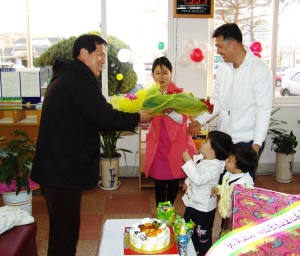 ▲ 한일도(왼쪽) 오천읍장이 세번째 자녀를 출산한 안정서·김현숙씨 부부에게 축하 꽃다발을 전달하고 있다.