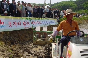 ▲ 경북도농업기술원이 상주시 사벌면 금흔리에서 새 벼농사법인 무논 골 점파재배기술을 시연하고 있다.
