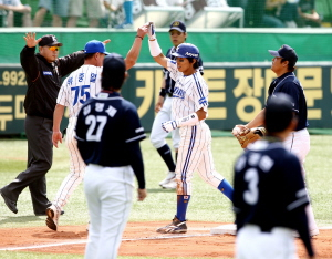 ▲ 15일 대구시민야구장에서 열린 삼성과 두산의 프로야구 경기에서 삼성 김동현(가운데)이 5회말 무사 1, 2루 때 2타점 3루타를 친 뒤 두산 선수들이 지켜보는 가운데 류중일 3루 코치와 기쁨을 나누고 있다. 삼성 라이온즈 제공
