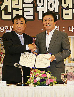 ▲ 이희범(왼쪽) 한국무역협회 회장과 김범일 대구시장이 대구무역회관 건립을 위한 업무협정을 맺은 뒤 악수하고 있다. 대구시 제공
