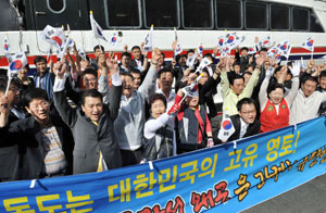 일본 교과서 해설서에 독도 영유권 명기 방침에 항의하기위해 김관용 경북도지사와 이상천 경북도의회의장 등 도청 관계자와 시도민들이 14일 오전 독도를 향했다. 울릉도 도동항 선착장에서 독도로 향하기전 참가자 등이 일본을 규탄하는 구호를 외친 뒤 만세삼창 하고 있다. 정우용기자 vin@msnet.co.kr