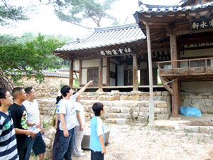 한주종택의 한주정사에서 한 학생이 외국인에게 정자에 대해 설명하고 있다.