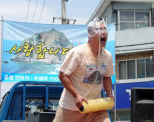 ▲ 조각가 윤명국씨가 고령 장터에서 일본의 독도 영유권 주장을 규탄하는 퍼포먼스를 펼치고 있다.