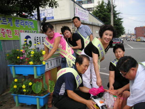 ▲ 경산시 남부동 바르게살기위원회 회원들이 제작·설치한 쓰레기 재활용 분리 수거대에서 분리수거 작업을 하고 있다.