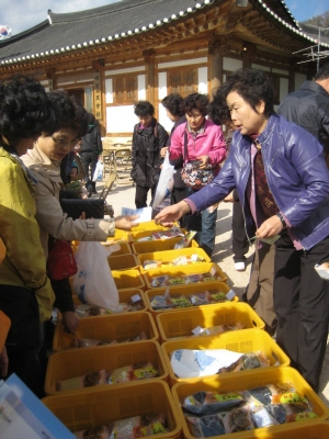 ▲ 농촌체험에 참가한 대한주부클럽회원들이 농업인들이 준비한 농산물을 구매하고 있다.