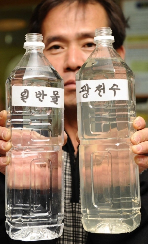 ▲ 2일 오전 대구시 수성구 중동 한 사우나 직원이 미네랄 성분이 다량 함유된 광천수를 일반 물과 비교하며 들어보이고 있다. 정운철기자 woon@msnet.co.kr