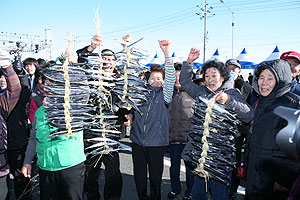 ▲ 과메기 빨리 엮기 경연대회에 참가한 관광객들이 엮은 과메기를 높이 들어 올리며 밝은 표정을 짓고 있다. 강병서기자
