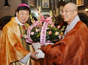 ▲ 성탄절인 25일 동화사 허운(오른쪽) 주지스님이 천주교 대구대교구 주교좌 계산성당을 방문, 조환길 총대리 주교에게 아기 예수님의 탄생을 축하하며 꽃바구니를 전달하고 있다. 정운철기자 woon@msnet.co.kr