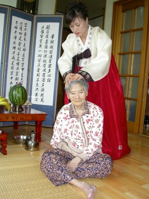 ▲ 시어머니 김남이(96.아래)씨의 머리를 다듬고 있는 중국 출신 이주여성 종부 윤계화씨.
