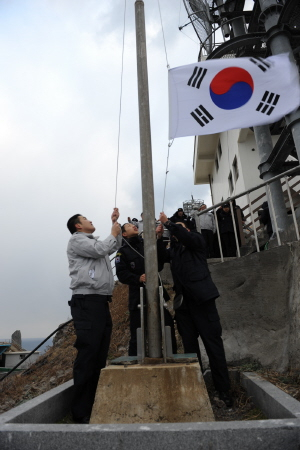 ▲ 설날 아침 독도경비대원들이 낡은 태극기를 내리고 새 태극기를 게양하고 있다.