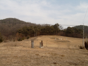 ▲ 정사 묘 전경. 전체적으로 오목한 형태다. 묘는 그 중심, 볼록한 곳에 위치하고 있다. 왼쪽에 솟은 봉우리가 옥녀봉이다.