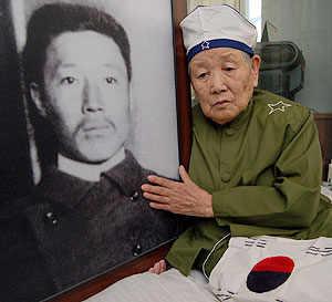 ▲ 중국 하얼빈에서 만난 안중근 의사의 조카며느리인 안로길(97) 할머니가 안 의사의 초상을 쓰다듬으며 옛일을 회상하고 있다. 사진 장성혁 인턴기자