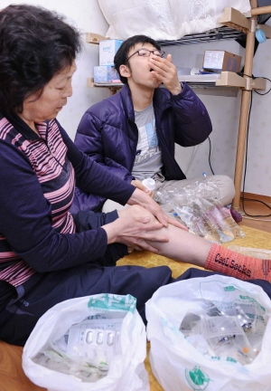 ▲ 류머티스 관절염과 당뇨를 앓는 김말희(53)씨와 만성신부전증을 앓는 작은아들 강정구(25)씨, 그리고 갑상샘중독증으로 고통받는 큰아들 왕탁씨까지 김씨네 집에는 약봉지가 아예 방 안을 가득 채우고 있었다. 정운철기자 woon@msnet.co.kr