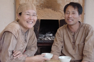 ▲ 황토집 안방 벽난로 옆에서 손수 만든 발효음료를 나누고 있는 조씨 부부.
