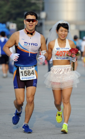 ▲ 오는 25일 결혼을 앞둔 예비부부 신기수씨(왼쪽)와 최진영씨가 결혼예식 복장으로 함께 달리고 있다. 김태형기자 thkim21@msnet.co.kr