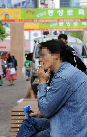 ▲ 27일 오후 금연거리로 지정된 대구 동성로 벤치에서 한 남성이 담배를 피우고 있다. 김태형기자 thkim21@msnet.co.kr