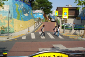 ▲ 예쁘게 단장한 평리초등학교 정문 앞을 학생들과 주민들이 즐겁게 통행하고 있다.