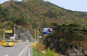 ▲ 일월면의 공룡혈. 산능선의 끝자락이 잘려 도로가 나 있다.