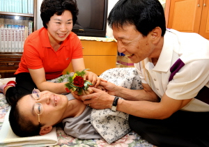 ▲ 대구 이곡중 도기호 선생님이 스승의날을 하루 앞둔 14일 10여년 전 처음 인연을 맺은 희귀성 난치병인 진행성 근육병에 걸린 제자 박정호씨와 어머니 김말순씨에게서 카네이션을 받고 있다. 이채근기자 mincho@msnet.co.kr