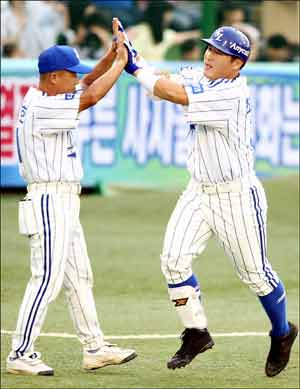 16일 대구시민야구장에서 열린 프로야구 경기에서 삼성 라이온즈의 최형우가 1회말 2사 1, 2루 때 두산 베어스 선발 투수 홍상삼을 상대로 우중월 3점 홈런을 친 뒤 김평호 코치의 환영을 받고 있다. 삼성 라이온즈 제공