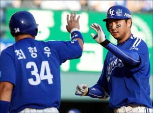 23일 서울 잠실구장에서 열린 프로야구 경기에서 삼성 라이온즈의 채태인이 1대2로 뒤진 2회초 무사 1루 때 두산 베어스 선발 투수 김선우를 상대로 역전 투런 홈런을 터뜨린 뒤 홈을 밟으며 앞선 주차 최형우의 환영을 받고 있다. 삼성 라이온즈 제공