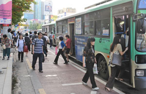 대구시내 버스가 준공영제로 운영되지만 승객편의는 뒷전이다. 23일 오후 2·28기념공원 앞 승강장에서 버스 이용 승객들이 승강장에 제대로 서지 않은 버스를 타기 위해 차도를 불편하게 걸어가고 있다. 성일권기자 sungig@msnet.co.kr