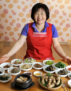 용두식당 주인 구윤임씨가 한상 가득 송이돌솥밥을 차려놓고 손님에게 권하고 있다.