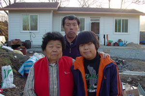 사랑의 집 고쳐주기 사업 18번째 수혜자인 상주 모서면 김강배씨 가족이 새집 앞에서 기념촬영을 했다.