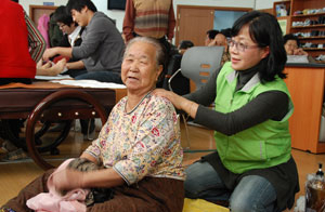 (Picture) A care manager from the Kyeongbuk Science University is massaging an old woman at the Elder