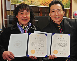 살인사건 용의자를 붙잡은 용감한 시민 김진호(왼쪽), 이경준씨가 표창장을 들어보이고 있다. 성일권기자 sungig@msnet.co.kr