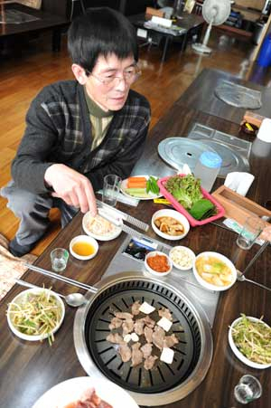 숯불간바지집 주인 이수한 씨가 달궈진 불판에 간바지를 구으며 설명하고 있다.
