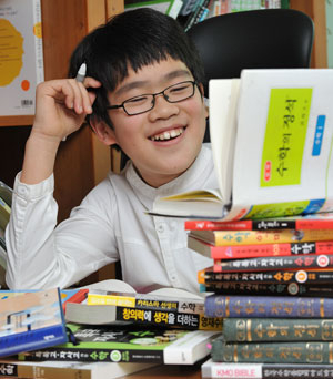 수학영재 이현수군이 수북하게 쌓인 수학책들을 보며 즐거운 표정을 짓고 있다.