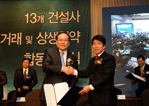 정동화(왼쪽) 포스코건설 사장이 13개 대형 건설사들을 대표해 협약이 체결됐음을 선포한 후 협력사 대표와 악수하고 있다. 포스코건설 제공