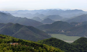 장륙산(686m) 육장굴 위 절벽에서 남서 방향으로 바라본 운문호 안의 동창천 모습. 앞으로 보이는 산줄기는 장륙능선 끝자락이고. 그 오른쪽은 수면이 낮아져 습지처럼 변한 후 고라니가 뛰놀게 된 상류 지촌리 구간 운문호 바닥이다. 그 뒤 오른편에서 길게 돌출한 것은 공암풍벽 능선, 그 왼편 큰 산줄기는 서지리 것이다. 그 다음 오른쪽 돌출봉은 바리박산(발백산)서 동곡리까지 내리달리는 