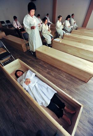 6일 오후 대구전문장례식장에서 열린 임종체험강좌에 참여한 체험자가 수의를 입은 채 관속에 들어가기 전에 유언장을 읽고 있다. 우태욱기자 woo@msnet.co.kr