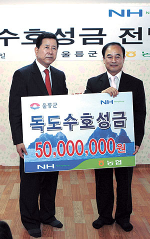 ▲최원병 농협중앙회장(왼쪽)이 김삼권 울릉군기획감사실장에게 