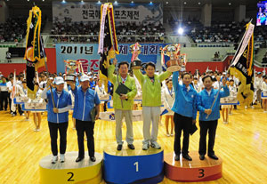 19일 포항체육관에서 열린 제48회 경북도민체전 폐회식에서 시부 1위 포항(가운데)과 2위 구미(왼쪽), 3위 경주 선수단 대표가 트로피와 기를 받고 기뻐하고 있다. 성일권기자 sungig@msnet.co.kr