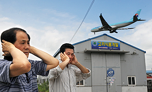 김해공항 활주로 인근 월포리 주민들이 여객기 소음에 귀를 막고 있다. 김태형기자 thkim21@msnet.co.kr