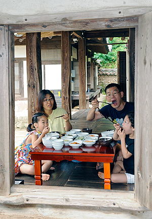 휴가철을 맞아 한옥 민박이 도시민들에게 인기를 끌고 있다. 지난달 29일 경북 안동시 풍천면 광덕리의 한 고택에서 하룻밤을 묵은 한 가족이 툇마루에 옹기종기 모여 앉아 아침식사를 하고 있다. 우태욱기자 woo@msnet.co.kr